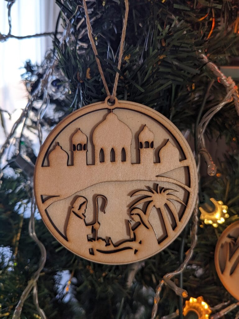 ornement de sapin de noël double homme bâton femme enfant palmier sous une ville