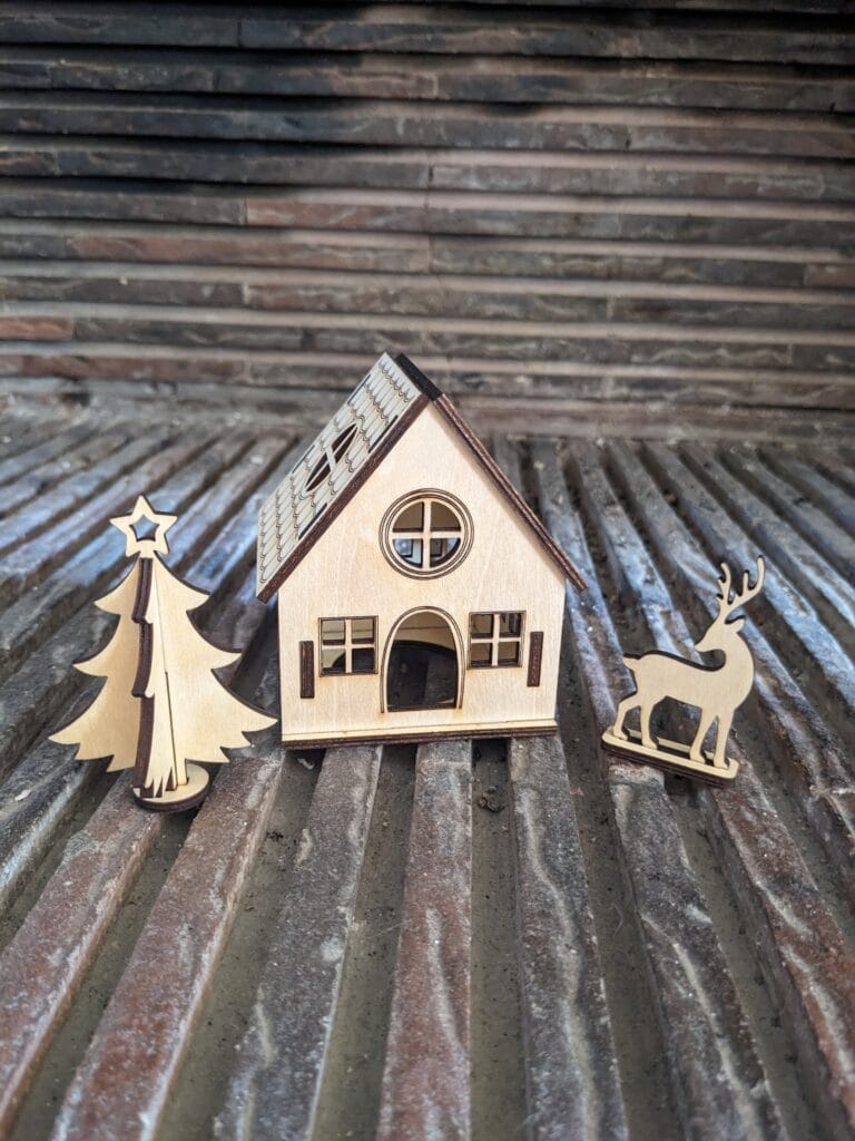 village de noël maison fenêtre ronde vu face avec accessoire sapin cerf